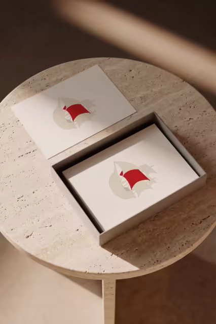 Postcard Mockup With a Gift Box on Travertine