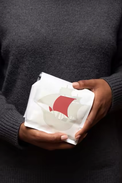 Pouch Mockup Held Against a Charcoal Sweater