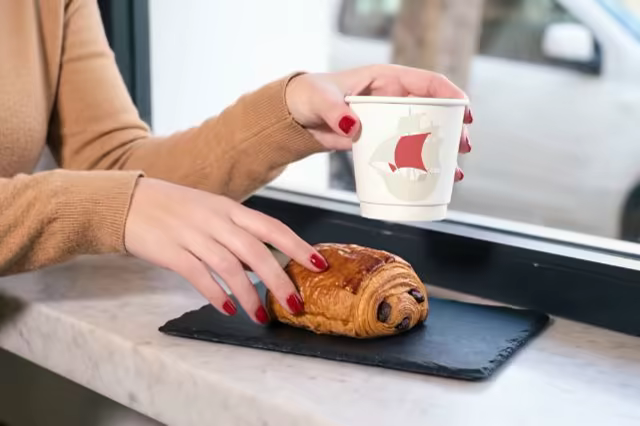 Coffee Cup Mockup With a Pastry by a Window