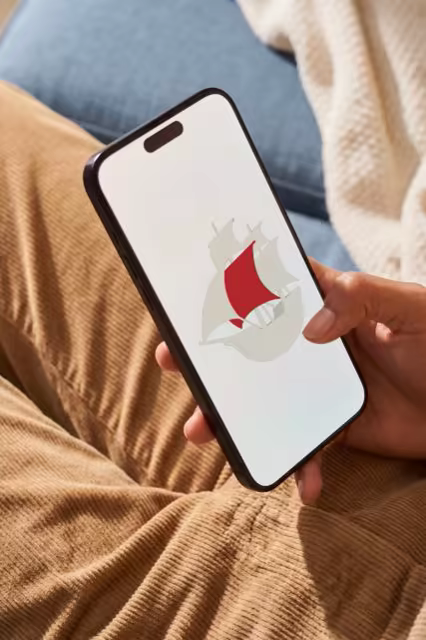 Phone Mockup in Hand on a Cozy Couch