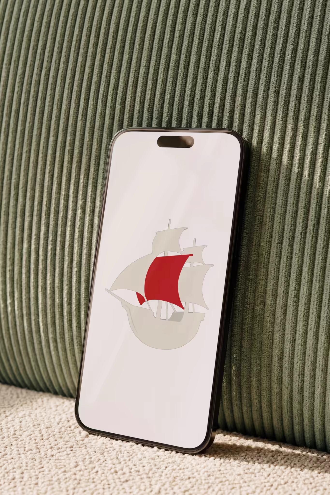 Phone Mockup Leaning on a Green Corduroy Sofa