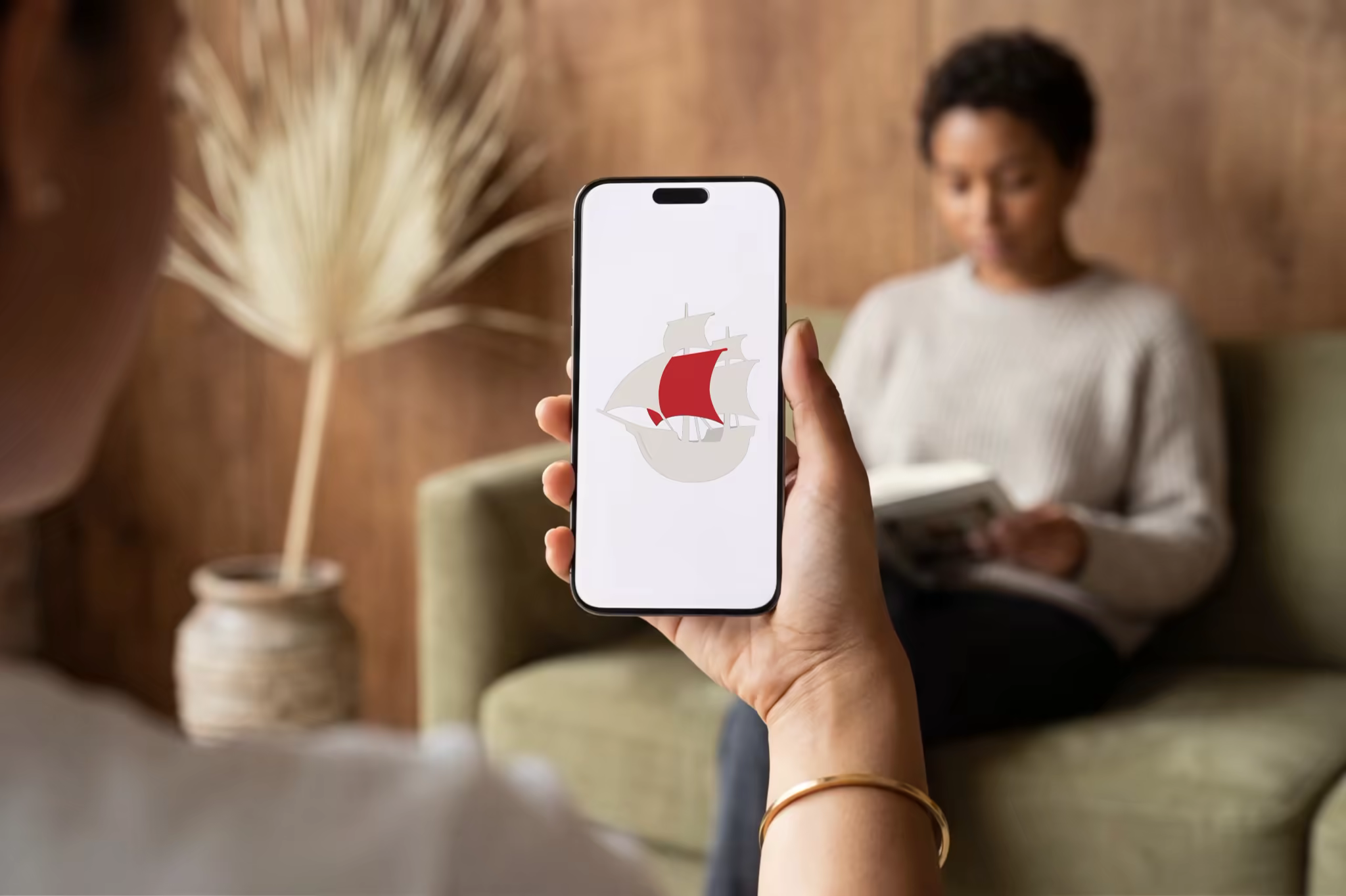 Phone Mockup Held in a Wood Paneled Room