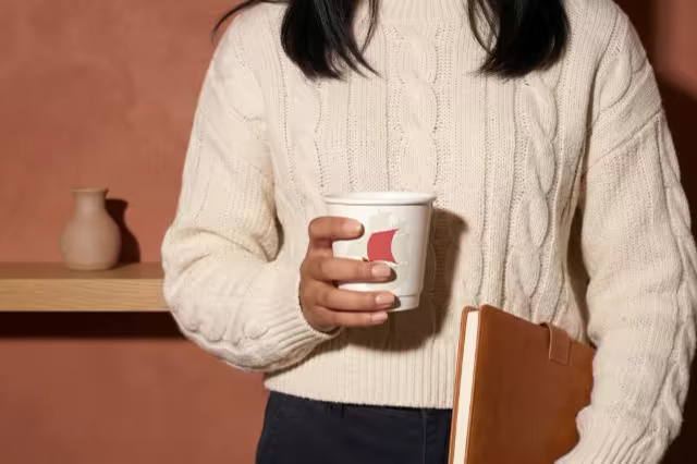 Paper Coffee Cup Mockup Held in a Knit Sweater