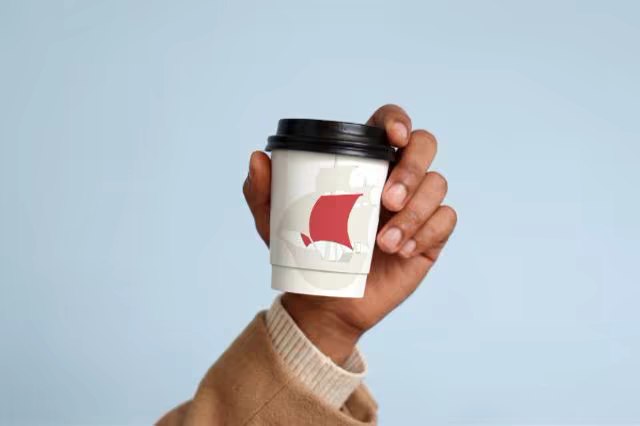 Lidded Coffee Cup Mockup Held Against Pale Blue