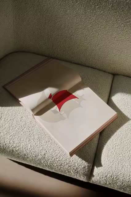 Open Book Mockup on a Cream Boucle Sofa