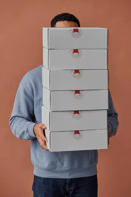 Stacked Mailer Boxes Mockup Against a Terracotta Wall
