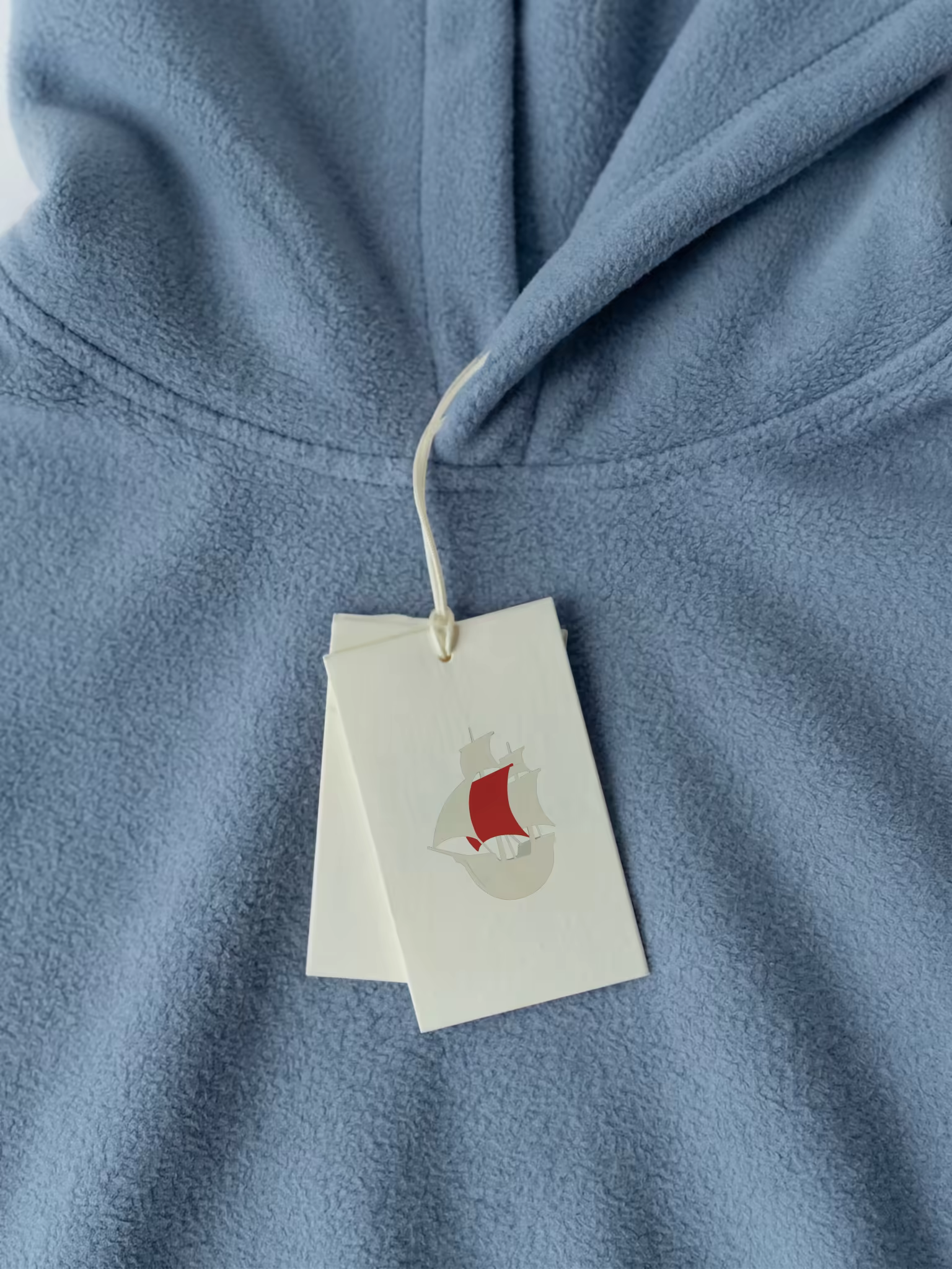 Hang Tag Mockup on a Light Blue Fleece Hoodie