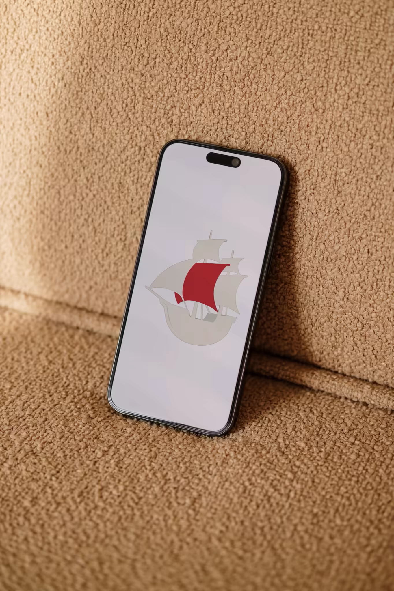 Phone Mockup Leaning on a Camel Boucle Sofa