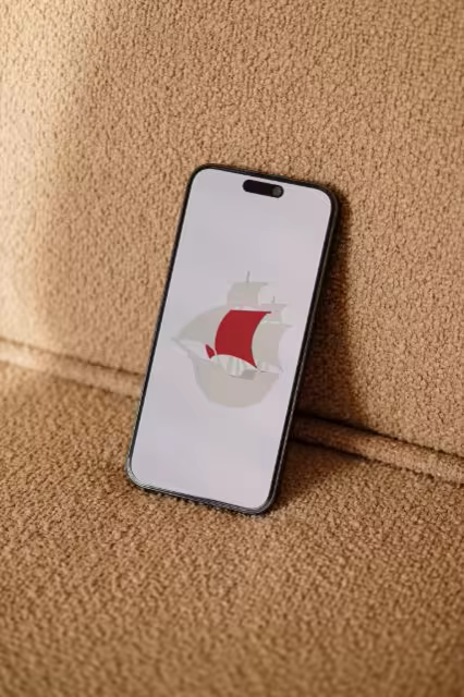 Phone Mockup Leaning on a Camel Boucle Sofa