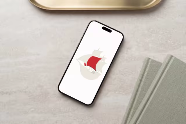Phone Mockup Beside a Brass Tray and Notebooks