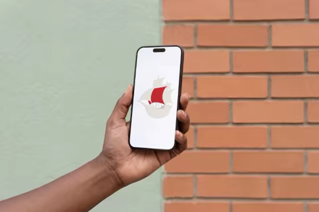 Phone in Hand Mockup by a Mint and Brick Wall