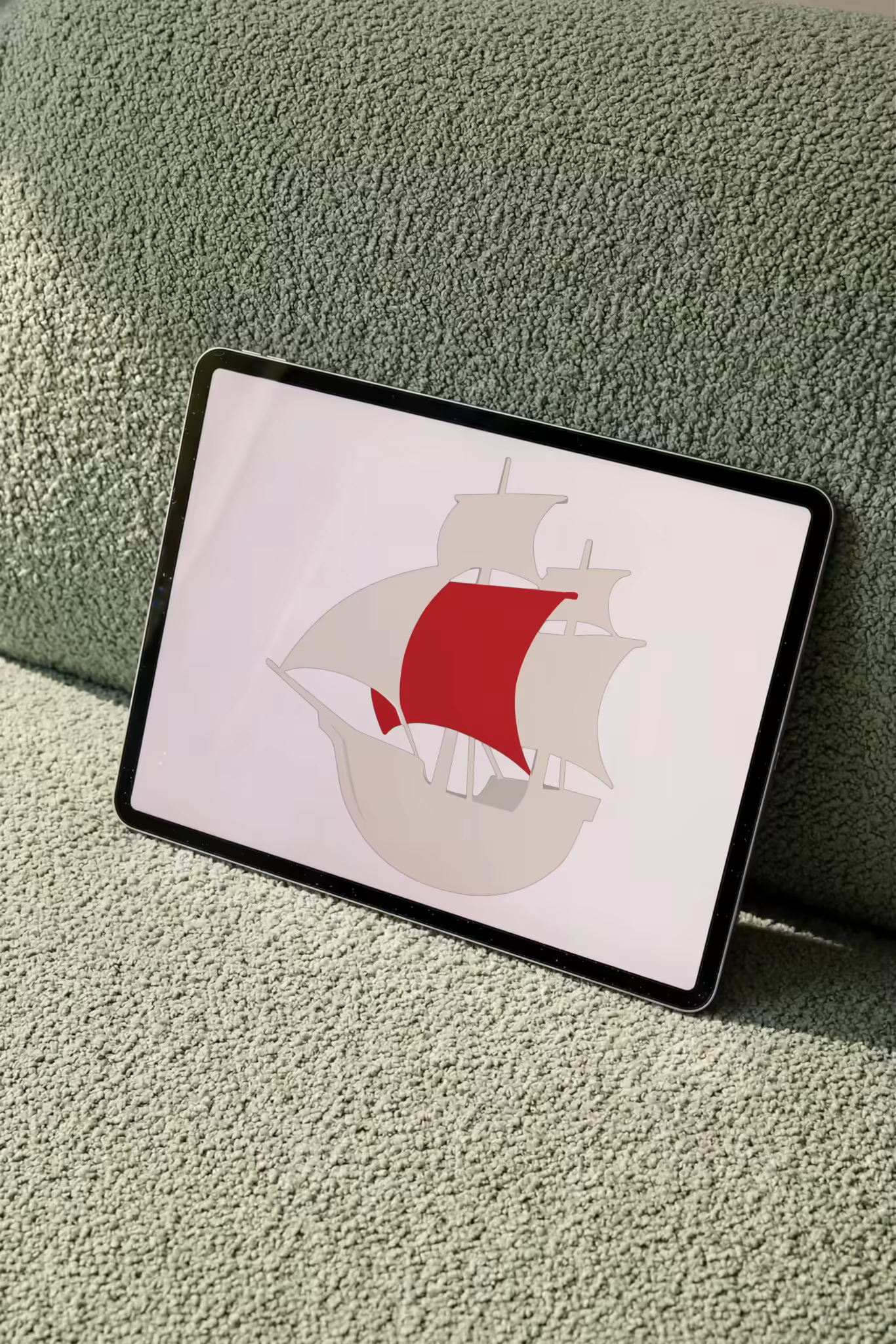 Tablet Mockup Leaning on a Sage Boucle Sofa