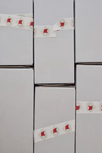Printed Tape Mockup Across Stacked Gray Parcels