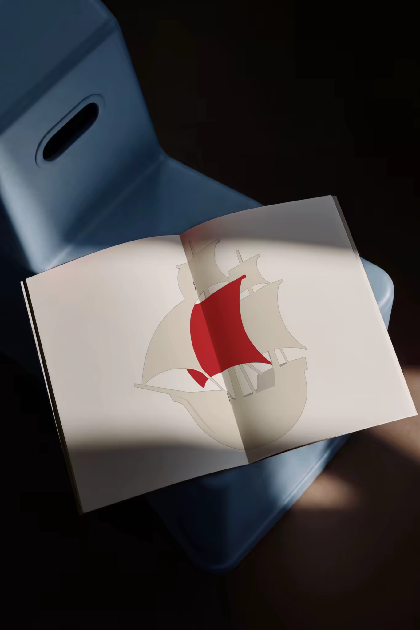 Open Book Mockup on a Blue Stool in Dim Light