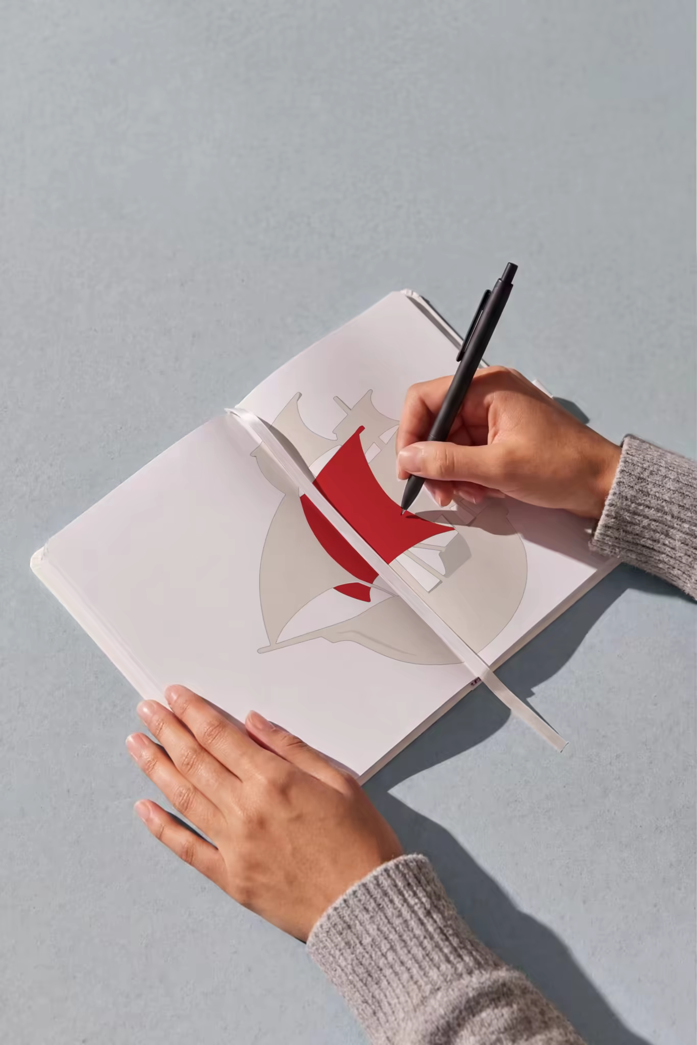 Open Notebook Mockup With a Pen in Hand