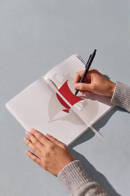 Open Notebook Mockup With a Pen in Hand