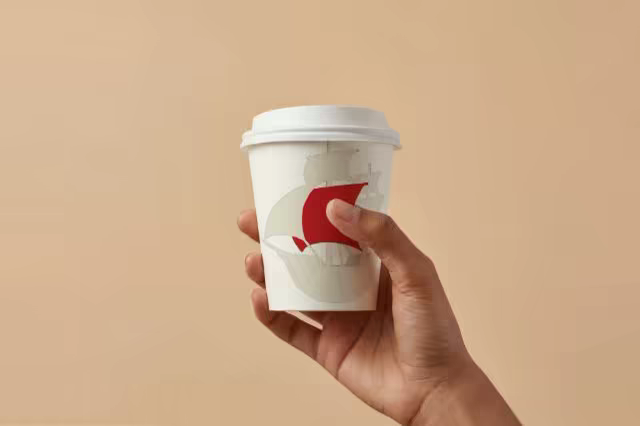 Paper Coffee Cup Mockup Held on Warm Beige