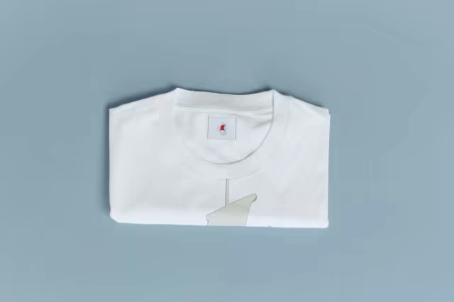 Folded T-Shirt Mockup on a Cool Blue Backdrop